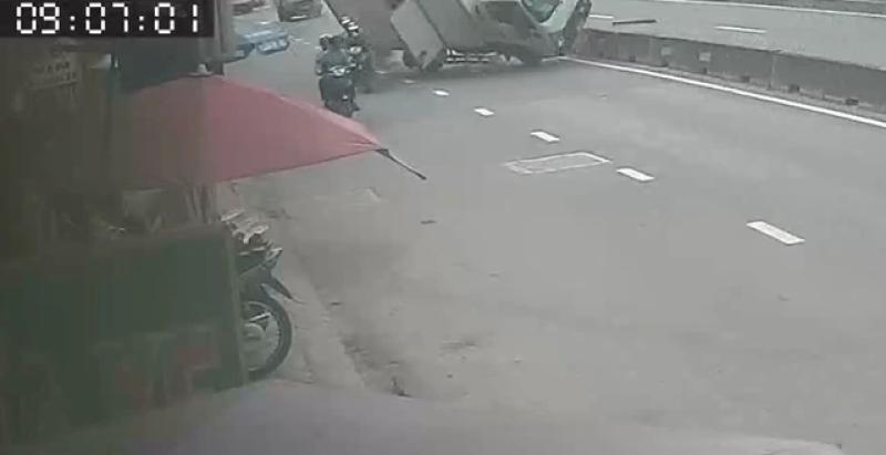 Ớn lạnh clip xe tải tông dải phân cách, suýt đè trúng 2 người đi đường - Ảnh 1.