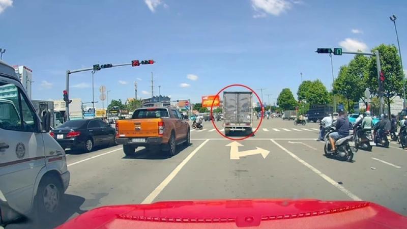Xe tải ngang nhiên vượt đèn đỏ, luồn lách giữa hàng xe để băng qua giao lộ - Ảnh 1.